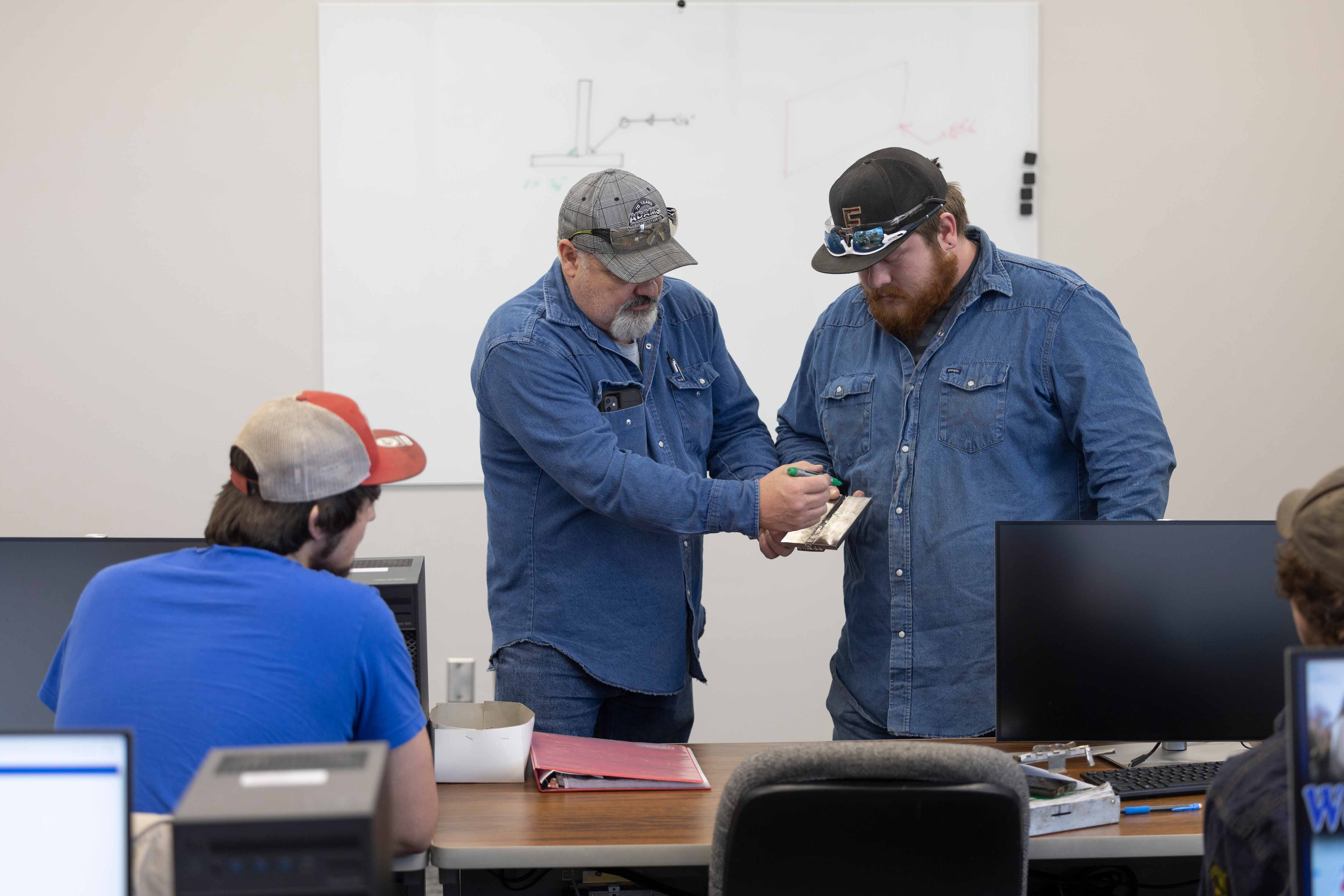 Instructors teaching about welding