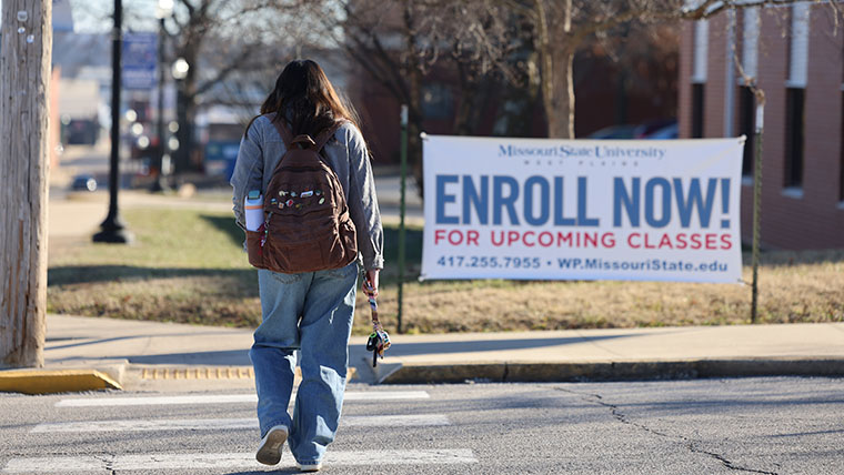 Student Walking across Road Enroll No Sign