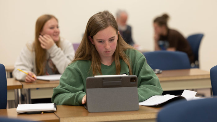 Student reading course documents on her iPad