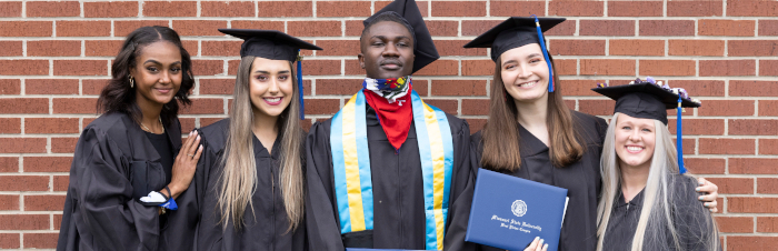 students in cap and gown on graduation day