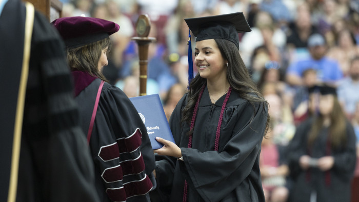 graduating student receiving her diploma
