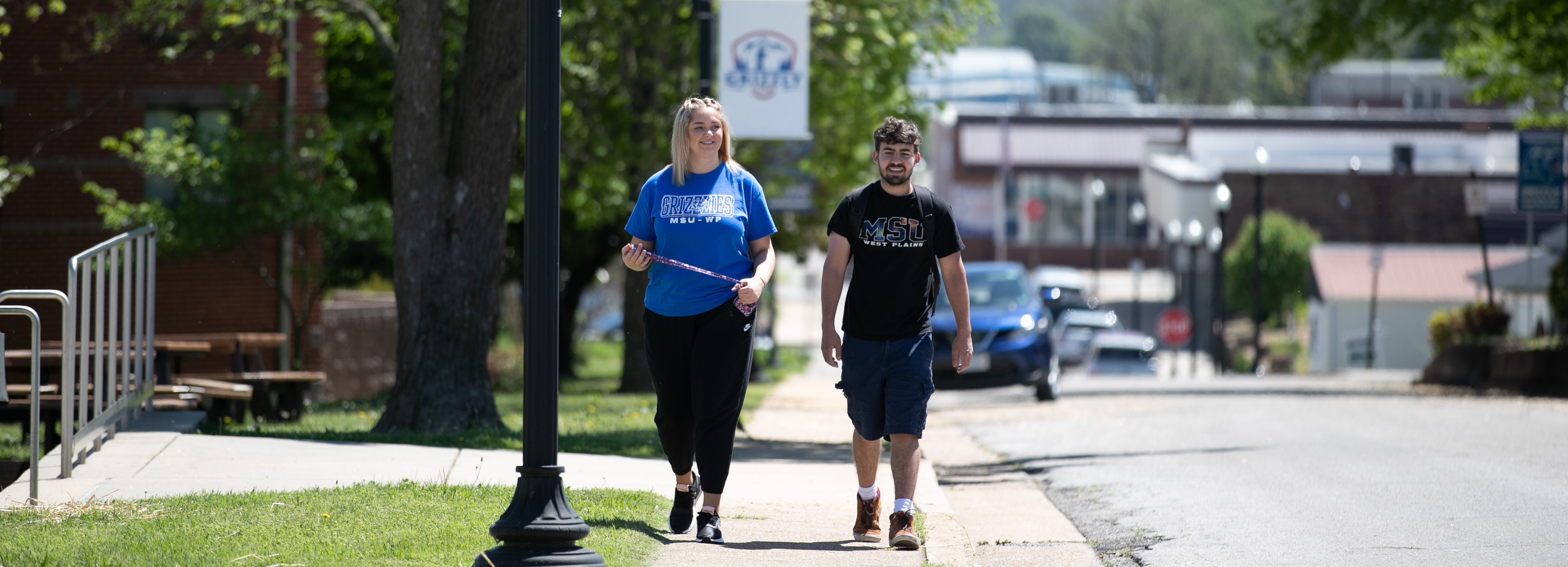 Two students walking outside of Hass-Darr Hall in Spring