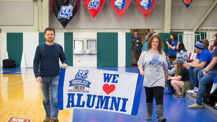 Missouri State student holding a banner - We love alumni