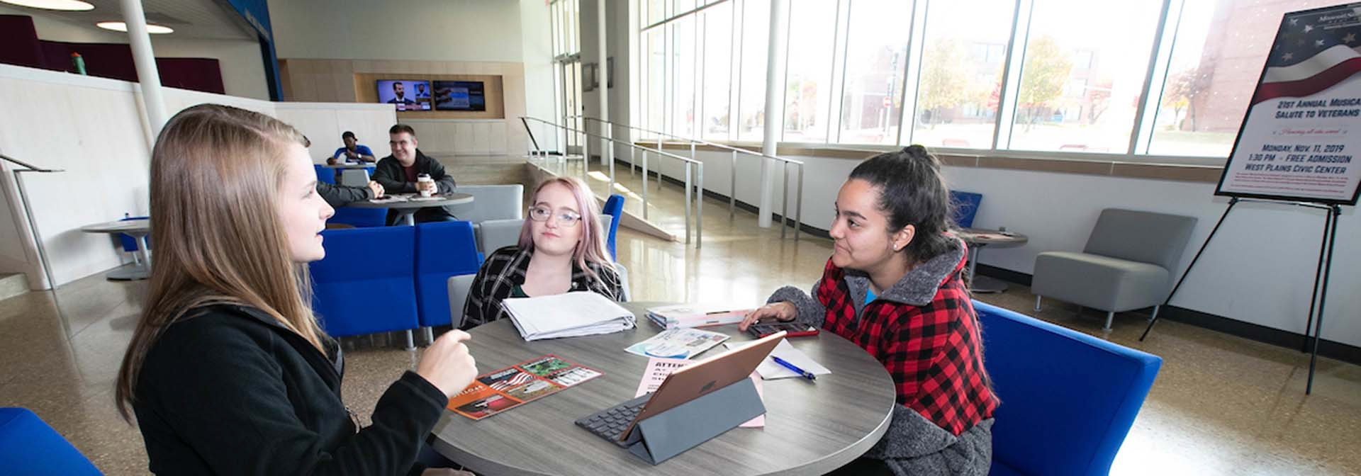 Three students discussing at a table