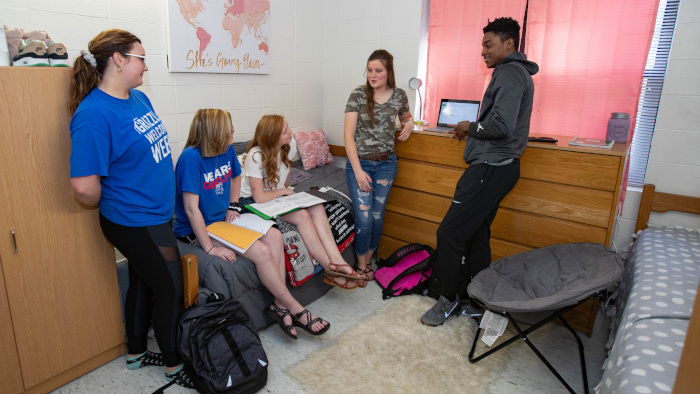 Five students talking in Grizzly House room