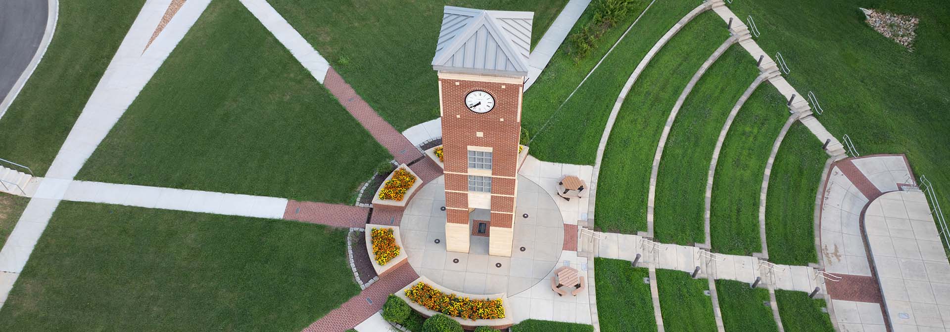 Sidewalk pathways and seating spreading out from the Bell Tower