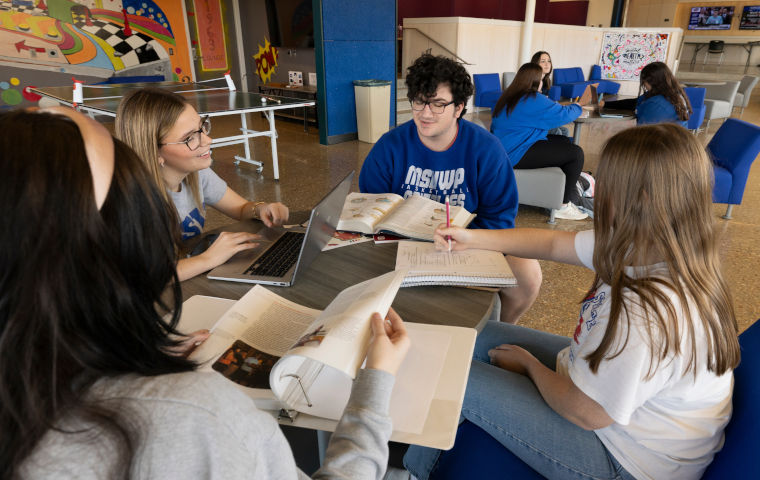 Four students talking at a table in the Carol Silvey Student Union