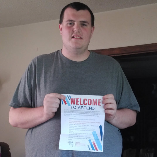 William Cole holds his ASCEND acceptance letter while smiling