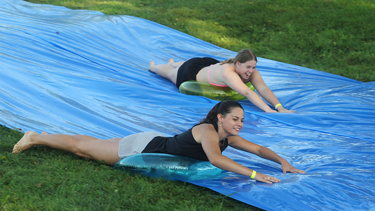 Students riding down on the slip n slide at Welcome Week 