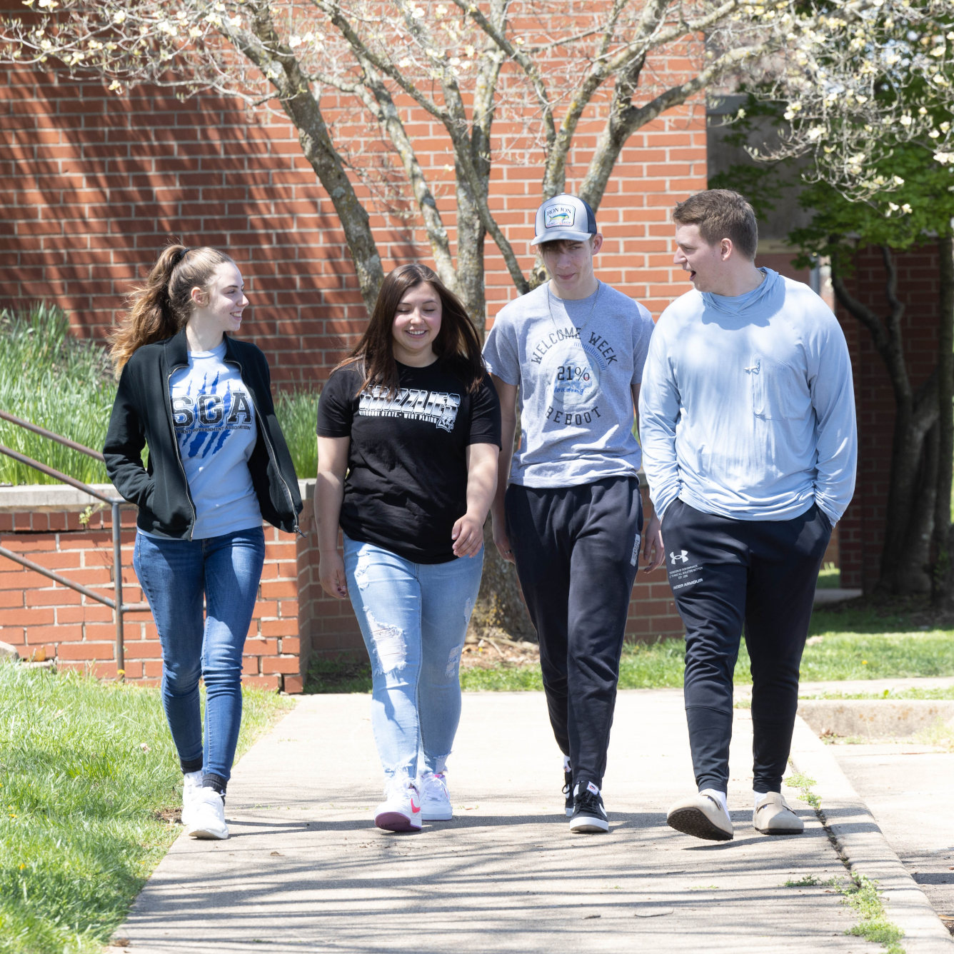 Four students wearing Grizzly Gear walking on campus